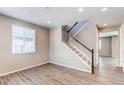 A bright living room with light-colored walls, wood floors, staircase, and windows that let in plenty of natural light at 27615 E Archer Ave, Aurora, CO 80018