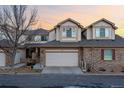 Charming townhouse features a two-car garage and a mix of brick and neutral siding at 3035 S Indiana St, Lakewood, CO 80228