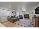Bright living room with ample natural light, gray sofa with throw pillows, and desk area with blue chair at 1143 Hummingbird Cir, Longmont, CO 80501