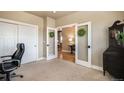 Well-lit office featuring neutral colors, plush carpet, double doors and a view into a connected living space at 17275 Gwilym Ct, Monument, CO 80132