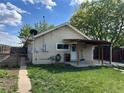 Backyard view with a well-maintained lawn, small garden, covered area, and partial fencing at 437 6Th St, Frederick, CO 80530