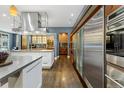 Modern kitchen features stainless appliances, wine storage, and beautiful hardwood floors at 235 Eudora St, Denver, CO 80220
