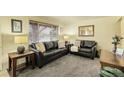 Cozy living room with dark leather seating and neutral carpet at 4108 S Inca St, Englewood, CO 80110