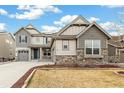 Two-story home with a three-car garage, gray siding, a stone foundation, and a manicured front lawn at 8783 S Winnipeg Ct, Aurora, CO 80016