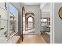 Elegant entryway showcasing a wooden arched front door, light hardwood floors, and views into the living spaces at 3613 Silverton St, Boulder, CO 80301