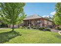 Landscaped front yard featuring a charming covered porch and beautiful greenery, enhancing the home's curb appeal at 2864 S Jebel Way, Aurora, CO 80013
