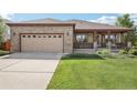 Charming brick home with a well-maintained lawn and covered front porch for relaxing and curb appeal at 2864 S Jebel Way, Aurora, CO 80013