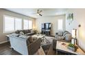 Bright living room with cozy seating, ceiling fan, and large windows overlooking neighborhood at 6954 E 117Th Ave, Thornton, CO 80233