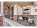 Cozy front porch with brick accents, comfortable seating, and a welcoming entrance at 4464 E 139Th Ave, Thornton, CO 80602