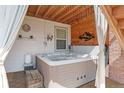 Outdoor hot tub and wooden accents in an enclosed space, with privacy drapes at 4464 E 139Th Ave, Thornton, CO 80602