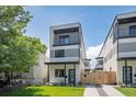 Modern three-story townhome featuring gray and white exterior, balcony, and well-maintained lawn at 1715 Grove St, Denver, CO 80204