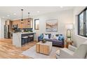 Stylish living room featuring hardwood floors, a modern sofa, and an open layout with kitchen at 1715 Grove St, Denver, CO 80204