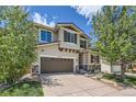 Charming two-story home features a well-maintained front lawn, mature trees, and a two-car garage at 10528 Applebrook Cir, Highlands Ranch, CO 80130