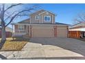 Charming two-story home showcasing a well-manicured lawn, inviting porch, and a convenient two-car garage at 2165 S Telluride Ct, Aurora, CO 80013