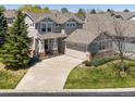 Charming two-story home featuring a well-manicured lawn, covered porch, and attached two-car garage at 13804 W 61St Cir, Arvada, CO 80004