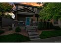 Two-story home at dusk, featuring stone accents and a well-manicured lawn, lit by outdoor lighting at 4578 Quandary Peak St, Brighton, CO 80601