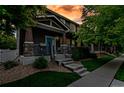 Two-story home at dusk, featuring stone accents and a well-manicured lawn, lit by outdoor lighting at 4578 Quandary Peak St, Brighton, CO 80601