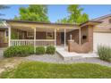 Inviting brick home with covered front porch featuring a swing, decorative brickwork, and manicured landscaping at 1048 N Columbine St, Golden, CO 80403