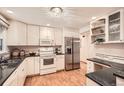 Bright kitchen with white cabinets, stainless steel appliances, granite countertops, and hardwood floors at 1048 N Columbine St, Golden, CO 80403
