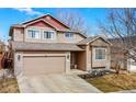 Inviting two-story home boasts a two-car garage and nicely landscaped front yard on a sunny day at 1622 Dyer Loop, Brighton, CO 80603