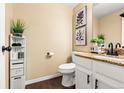 Stylish half bathroom with a granite countertop, white cabinetry, and decoratively organized storage at 1622 Dyer Loop, Brighton, CO 80603