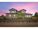 Stunning two-story home highlighted by a vibrant, colorful sky at sunset and meticulously crafted landscaping at 8623 S Wadsworth Ct, Littleton, CO 80128