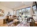 Bright living room with leather couch and large windows with a walk-out patio at 2525 S Pearl St, Denver, CO 80210