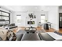 Modern living room with hardwood floors, fireplace, and a wall of windows at 3926 Kalamath St, Denver, CO 80211