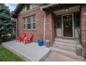 Inviting covered brick front porch with red chairs and a lantern, adding a touch of warmth at 726 S Corona St, Denver, CO 80209