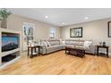 Bright living room featuring hardwood floors, a comfortable sectional sofa, and ample natural light from windows at 6782 Hills Dr, Parker, CO 80138