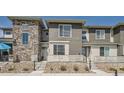 Townhome exterior featuring stone and siding details with a charming porch and low-maintenance landscaping at 16433 Askins Loop, Parker, CO 80134
