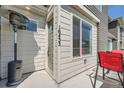 Inviting townhome front entrance featuring modern door, gray siding, and outdoor heating for all-weather comfort at 16433 Askins Loop, Parker, CO 80134