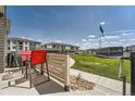 Community patio area with red table set, stone detail, and view of 'Lokal Homes' advertisement at 16433 Askins Loop, Parker, CO 80134