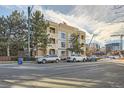 Condo building exterior showcasing urban setting and ample parking at 180 Cook St # 105, Denver, CO 80206