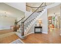 Elegant foyer showcasing a curved staircase with wood railings, and hardwood floors at 5528 S Jasper Way, Centennial, CO 80015