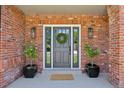 Charming front door framed by brick, potted plants and stylish lanterns at 5528 S Jasper Way, Centennial, CO 80015