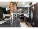 Well-equipped kitchen with black countertops, stainless steel appliances, and gray cabinets at 2700 S Holly St # 202, Denver, CO 80222