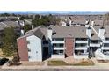 Exterior view of a multi-story home featuring brick accents, balconies, and a well-maintained landscape at 14495 E 1St Dr # C1, Aurora, CO 80011