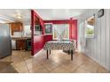 View of dining room with open access to kitchen, tile floors, and a window at 5942 Poplar St, Commerce City, CO 80022