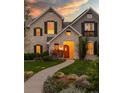 Charming two-story home with stone facade, black shutters, and landscaped front yard at 295 Jersey St, Denver, CO 80220