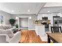 Open concept living and kitchen area with hardwood floors and modern cabinets at 4625 Webster St, Wheat Ridge, CO 80033