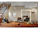Cozy living room features a sleek fireplace, comfortable seating, and a modern staircase at 865 Delaware St, Denver, CO 80204