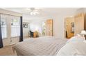Bright main bedroom features a ceiling fan, a desk, and a view to an ensuite and walk-in closet at 5959 S Willow Way, Greenwood Village, CO 80111