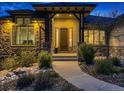 Inviting front porch with stone pillars and a cozy entrance at 5441 Twilight Way, Parker, CO 80134