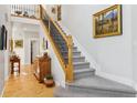Bright entryway featuring a staircase with a dark metal railing and wood floors at 12187 S Hidden Trail Ct, Parker, CO 80138