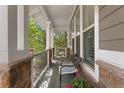 Charming covered porch with stone columns, wicker seating, and serene outdoor views at 12187 S Hidden Trail Ct, Parker, CO 80138