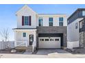 Charming two-story home with white siding, stone accents, a two-car garage, and a welcoming front porch at 1917 S Fultondale Way, Aurora, CO 80018