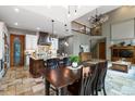 Open-concept kitchen and dining area with a large island and modern lighting fixtures at 9009 Rambling Oak Pl, Parker, CO 80134