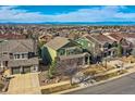 Aerial view of the green two-story home in a suburban neighborhood with mountain views in the distance at 25332 E Indore Dr, Aurora, CO 80016