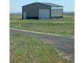 Large metal outbuilding with a roll-up door and pedestrian door, perfect for storage or workshop space at 15300 Cavanaugh Rd, Keenesburg, CO 80643